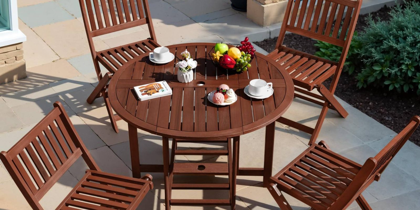 A table with a bowl of fruit and a book on it