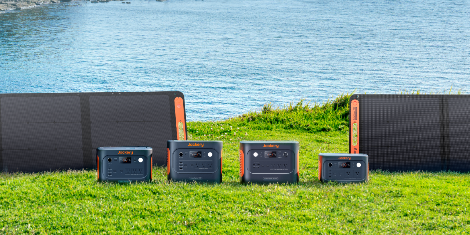 A group of electronic devices on grass by water