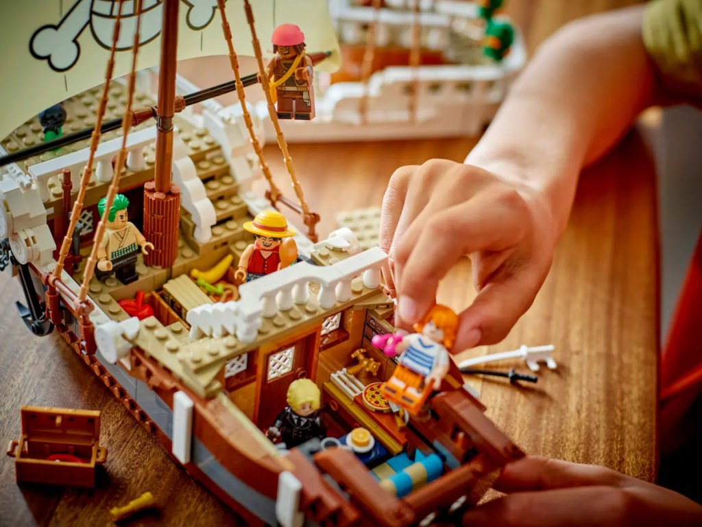 A hand holding a toy ship