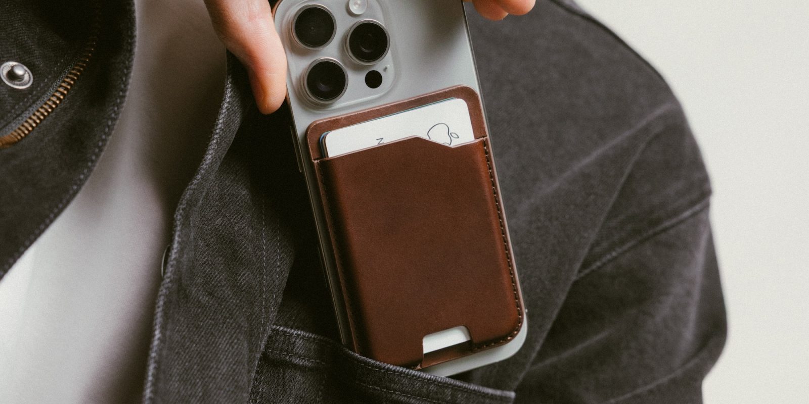 A person holding a phone with a leather case