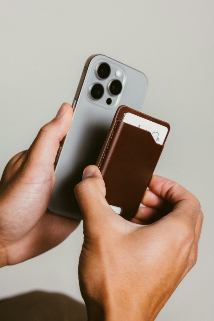 A person holding a phone and a wallet