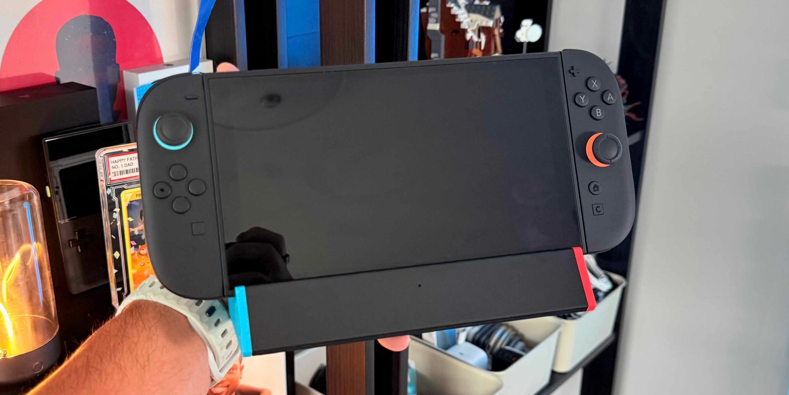 A hand holding a video game console