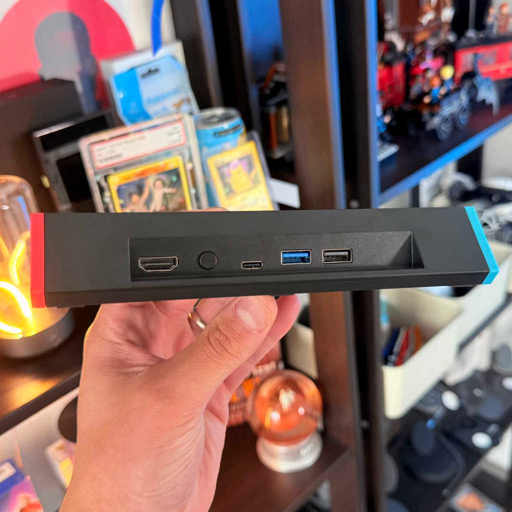 A hand holding a black rectangular device