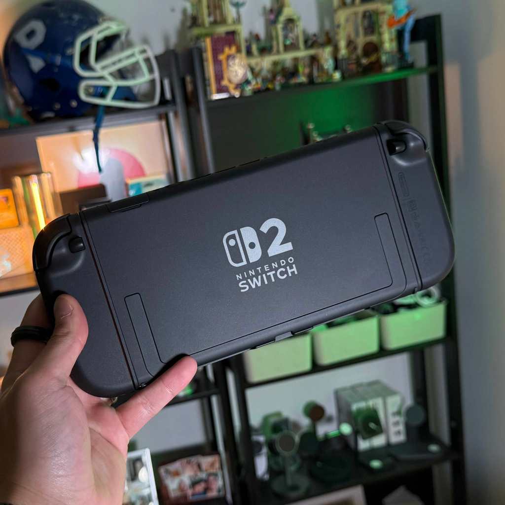 A hand holding a video game console