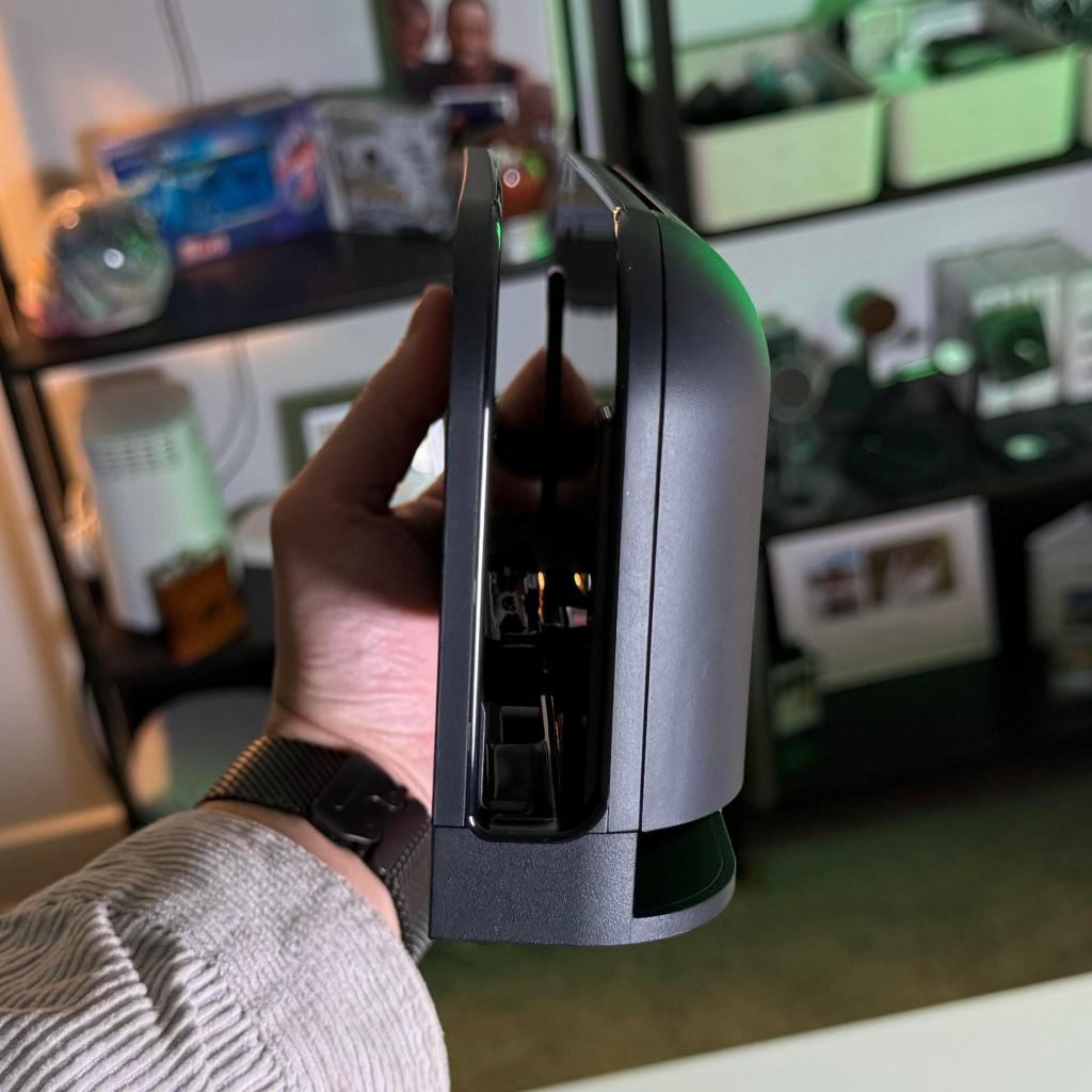 A hand holding a black device