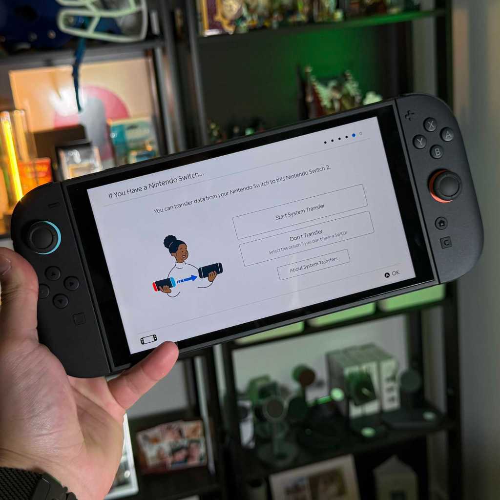 A hand holding a video game device