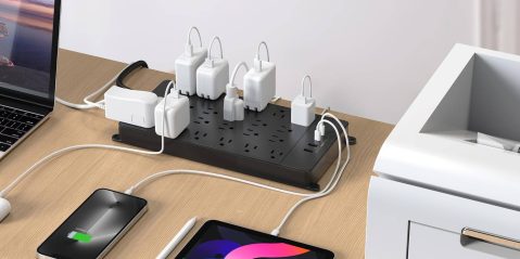 A black rectangular power strip with white cords connected to a black rectangular power strip