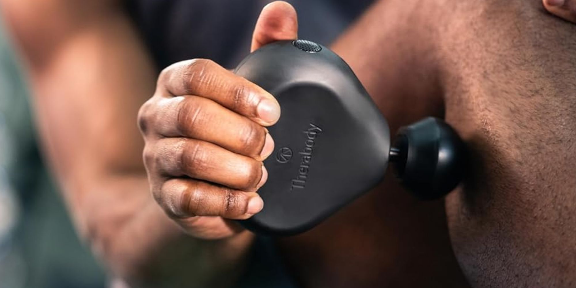 A person holding a massage gun.