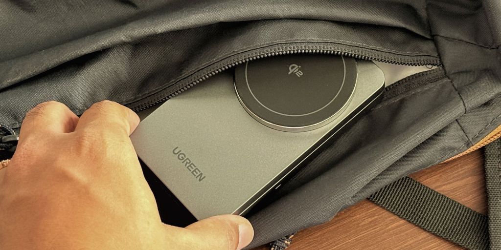 A hand holding a device in a bag