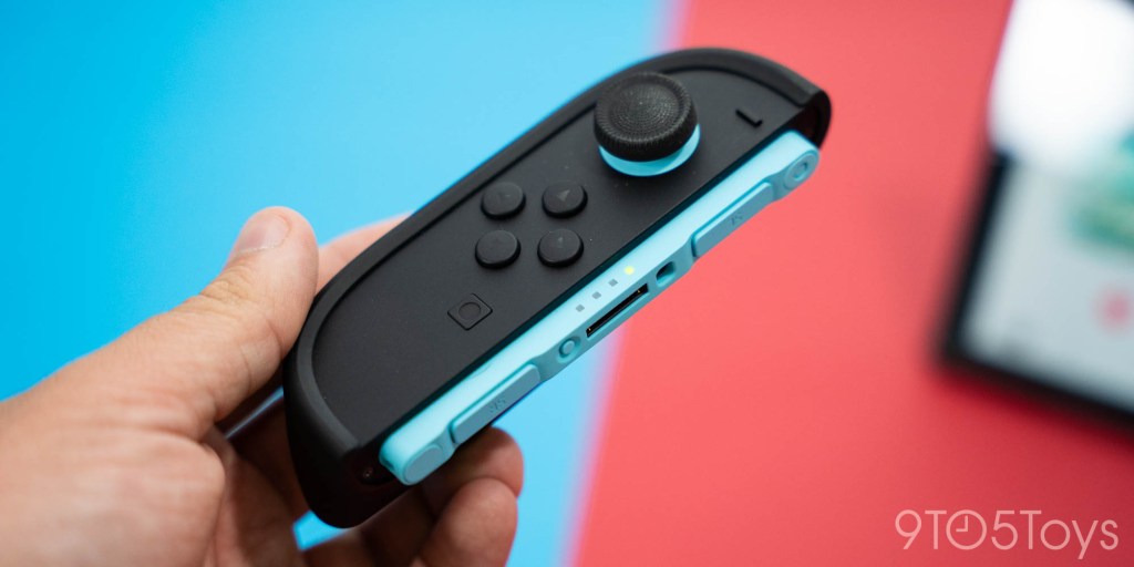 A hand holding a video game controller