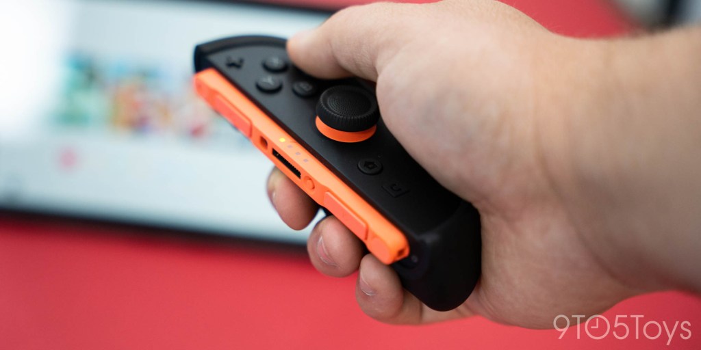 A hand holding a video game controller