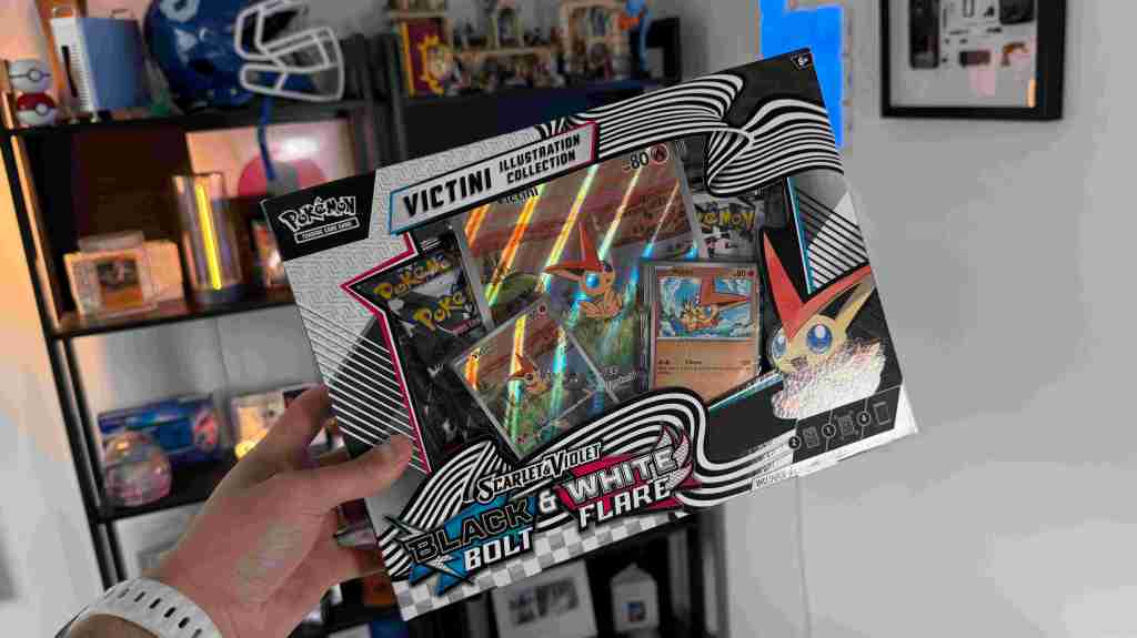 A hand holding a box of pokemon cards