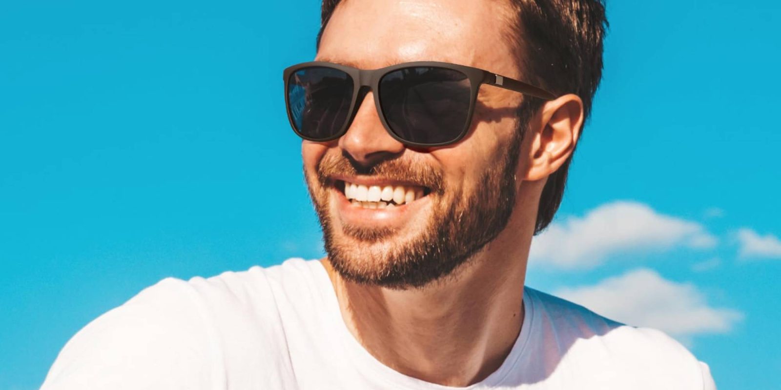 A man wearing sunglasses and smiling