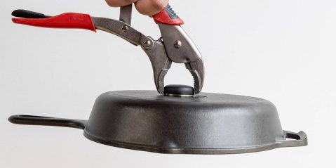 A hand holding a pliers