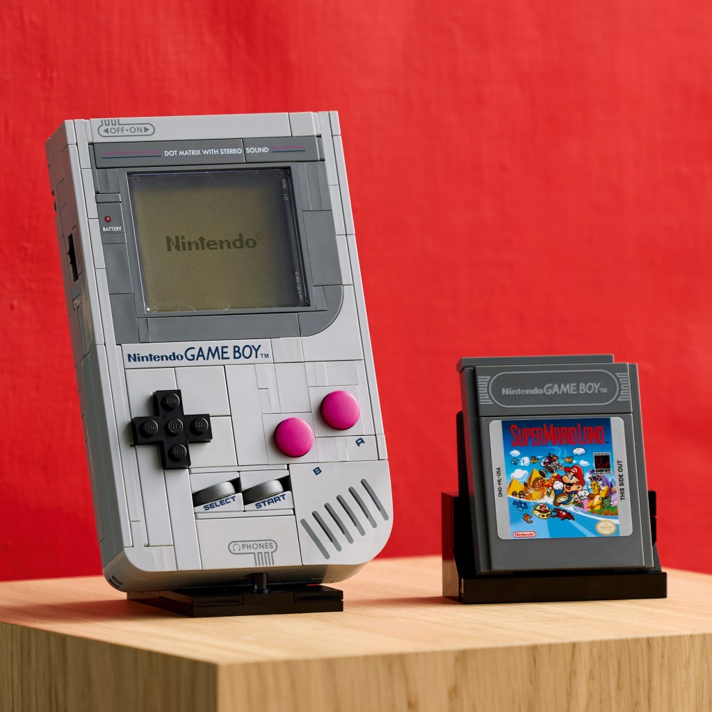 A grey handheld gaming device next to a black handheld gaming device