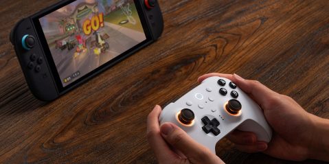 Image showing a person holding 8Bitdo's Ultimate 2 controller in white.