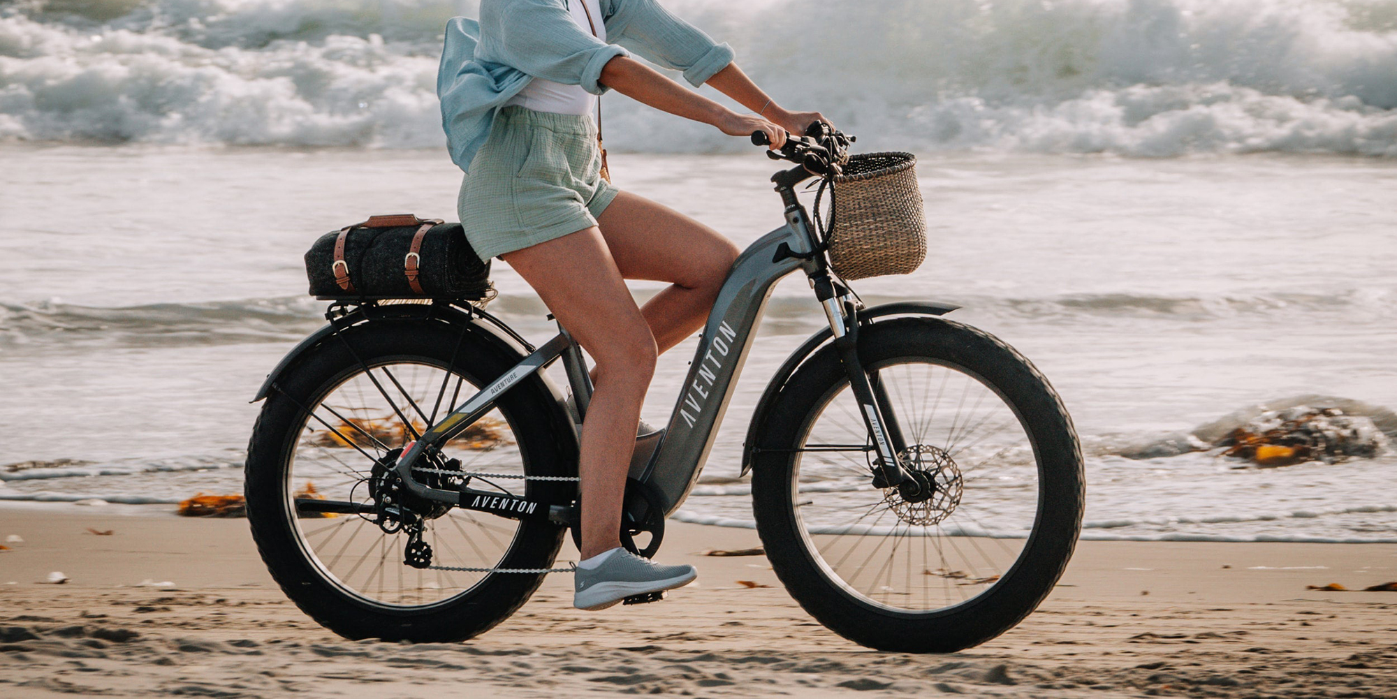 A woman riding a bike on the beach