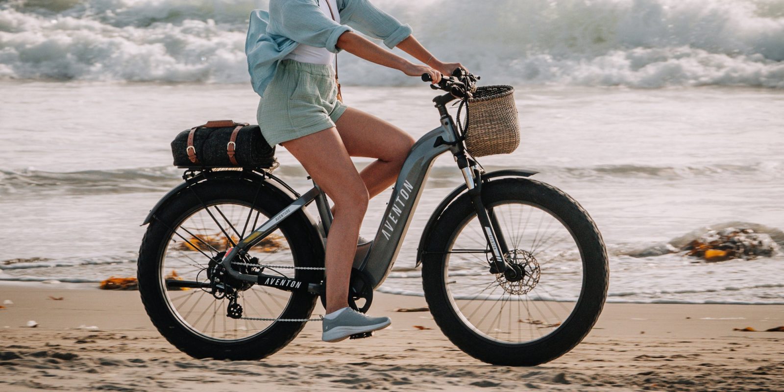 A woman riding a bike on the beach