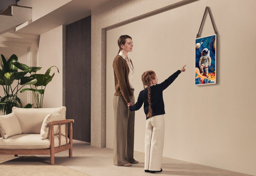 A woman and child looking at a picture on a wall