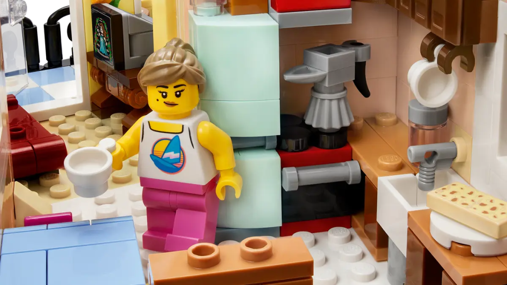 A lego girl standing next to a toy building