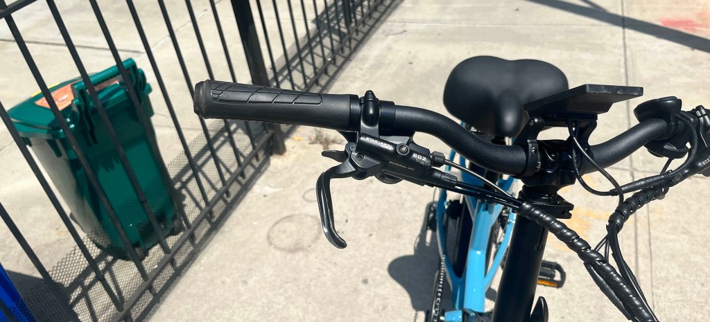 Lectric XP4 750 e-bike handlebars and a fence