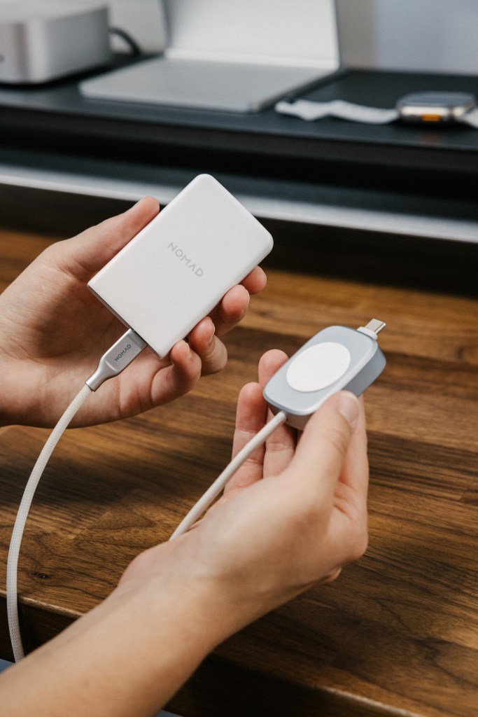 A person holding a charger and a cable