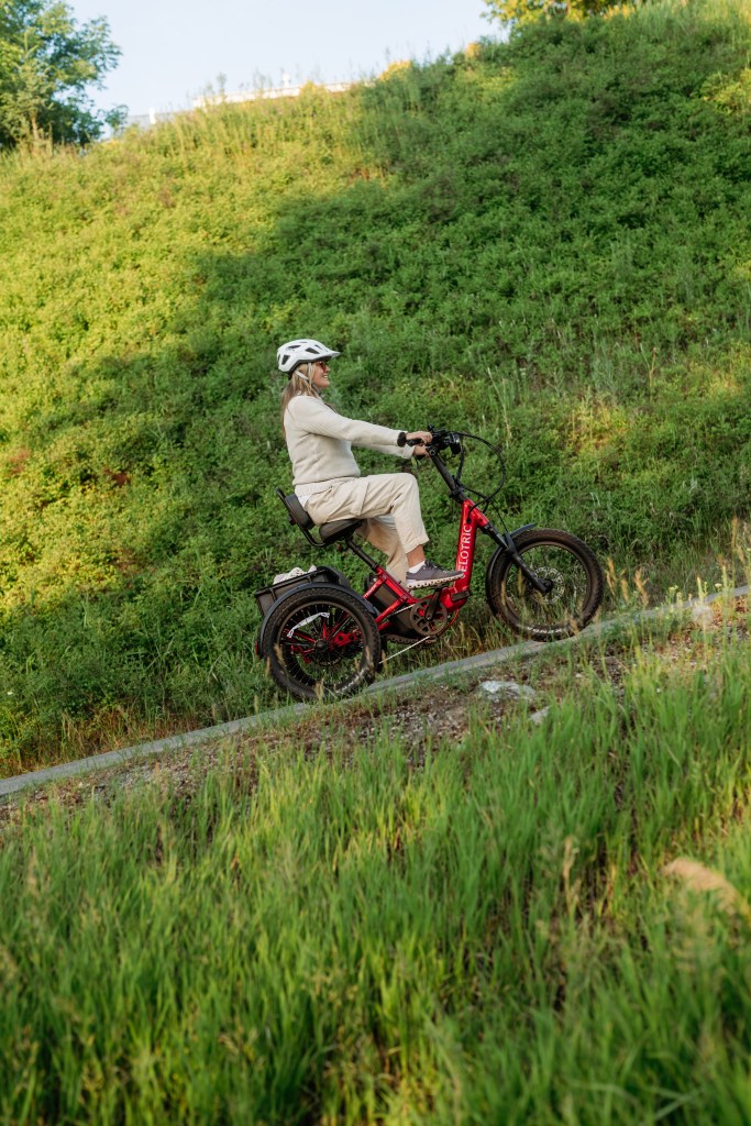 woman riding velotric's triker up a steep hill