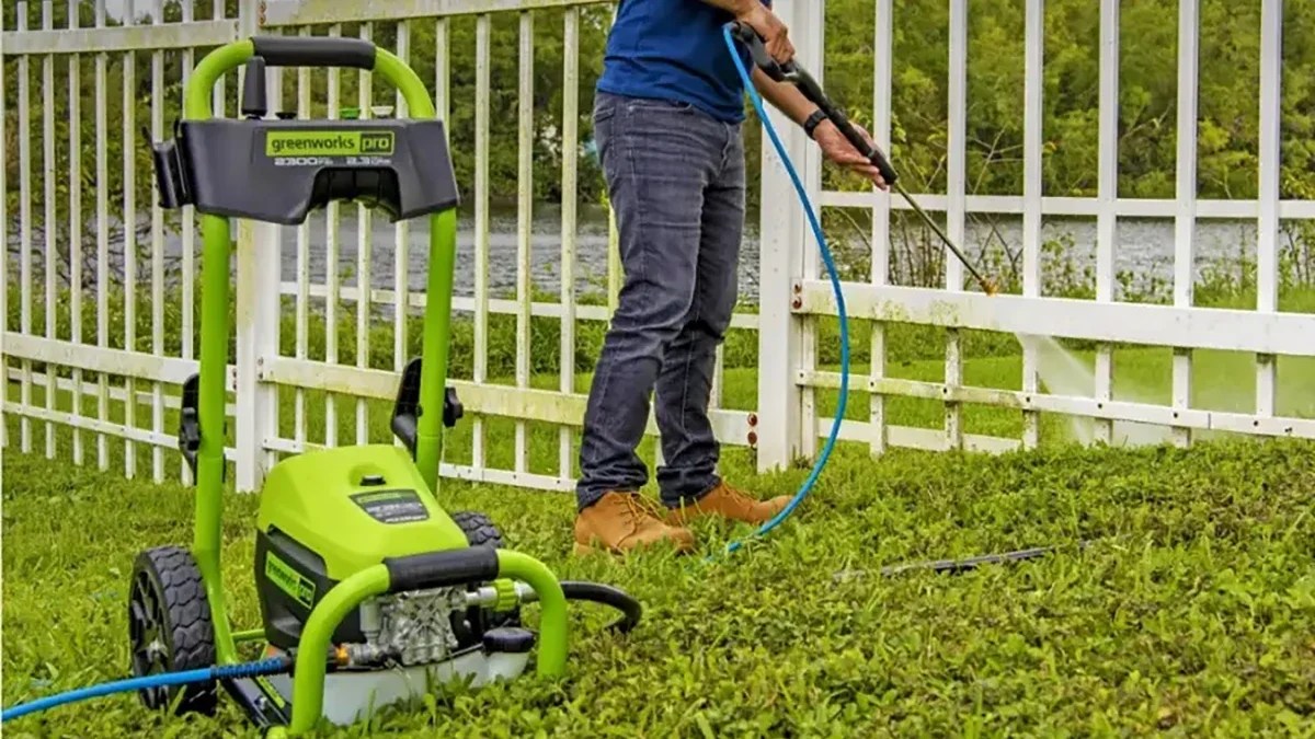 A person using a hose to clean the grass