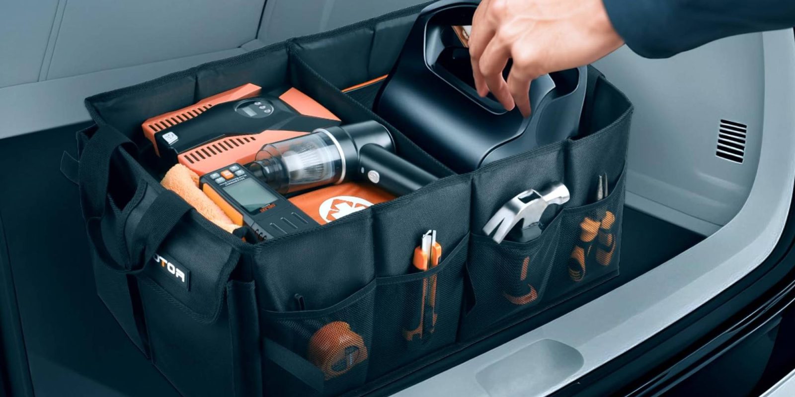 A hand opening a bag with tools