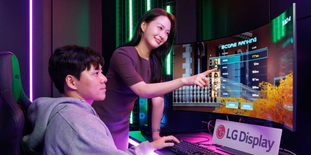 Image showing a women pointing towards a monitor for a person sitting next to her.