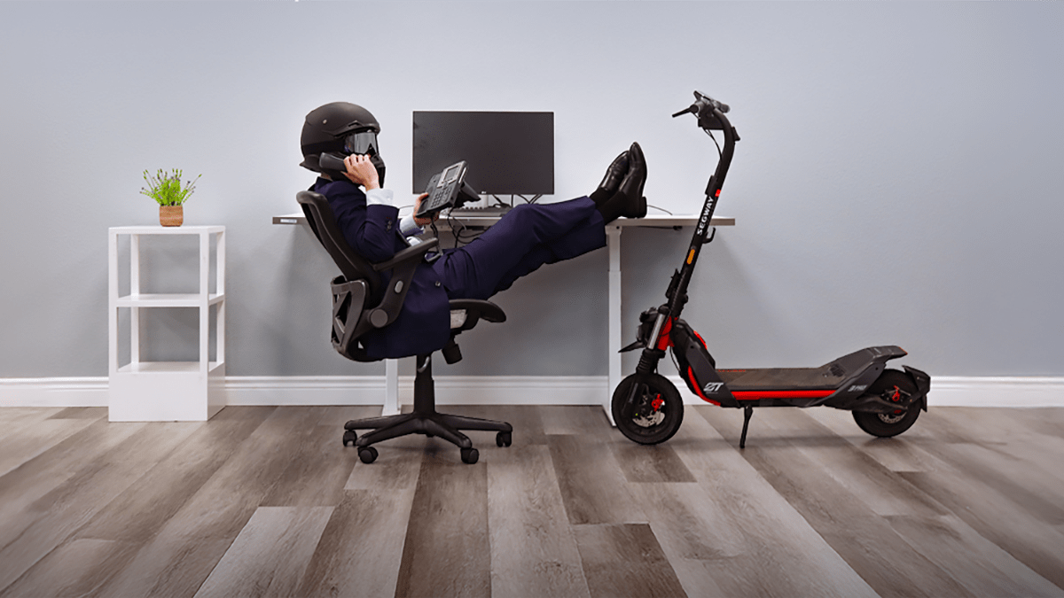 A person sitting in a chair with his feet on a desk and a helmet on the phone