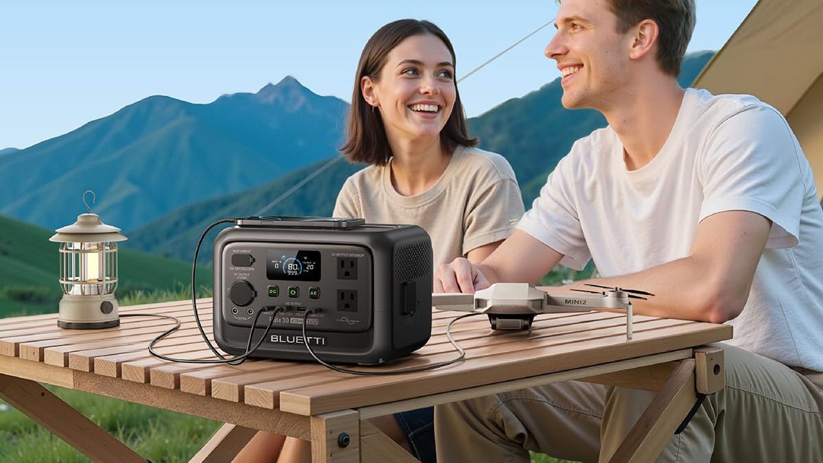 A man and woman sitting at a table with a device on it