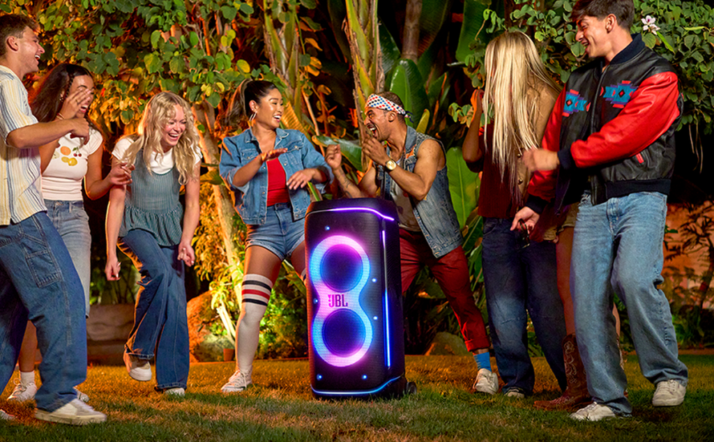 A group of people dancing outside around JBL's PartyBox 720 speaker