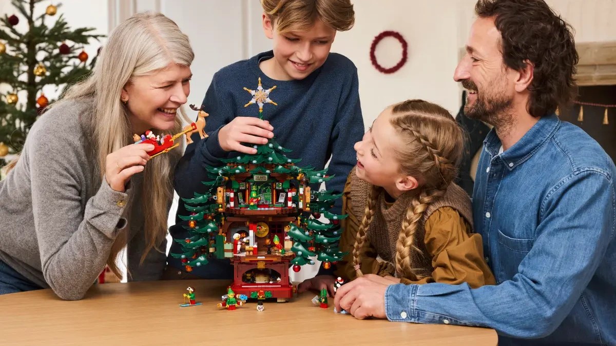 A group of people around a table with a tree made of lego