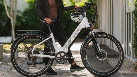 A woman holding a white bicycle