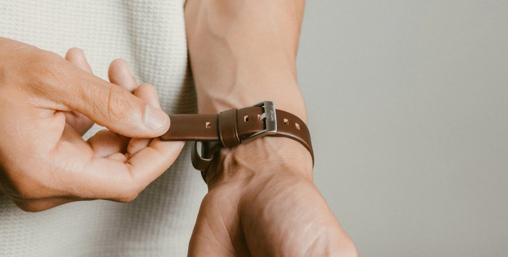 A person putting a watch on their wrist