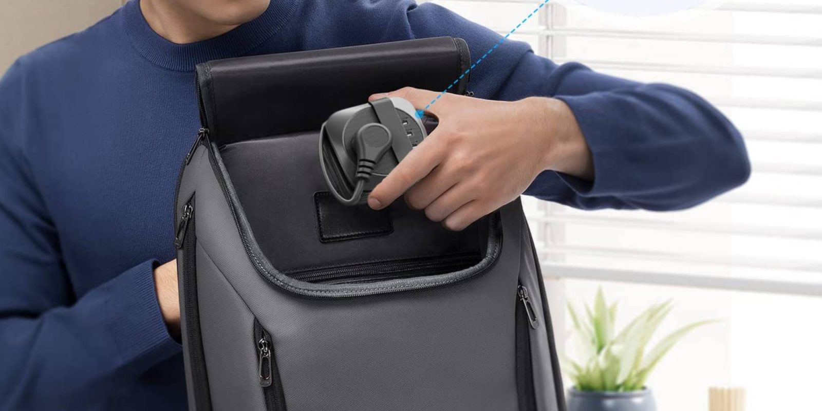 A person holding a charger in their backpack