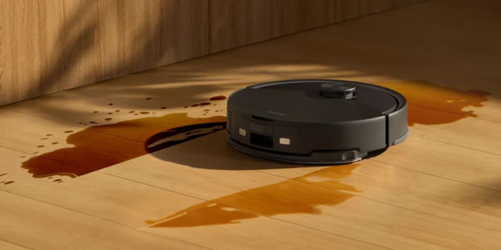A black robot vacuum on a wood floor