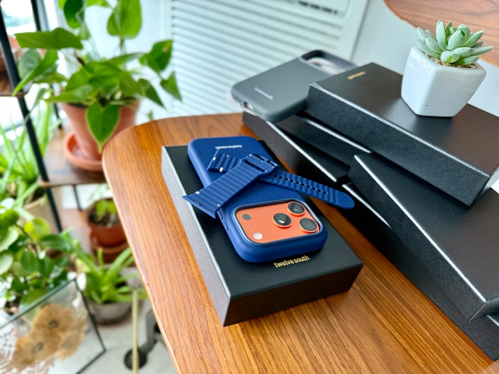 A blue cell phone with a blue strap on a black box