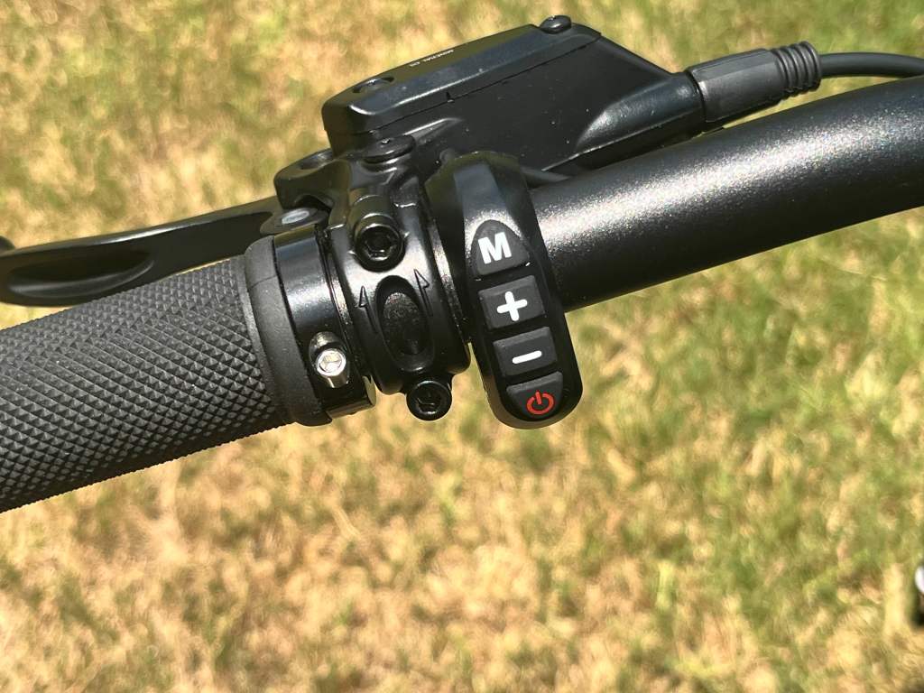 A handlebar with a button and a switch for the Ride1Up Revv1 DRT