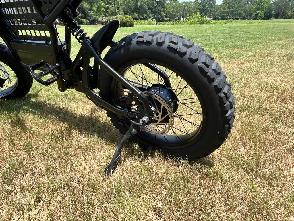 A black Ride1Up Revv1 DRT e-bike with a black tire on grass