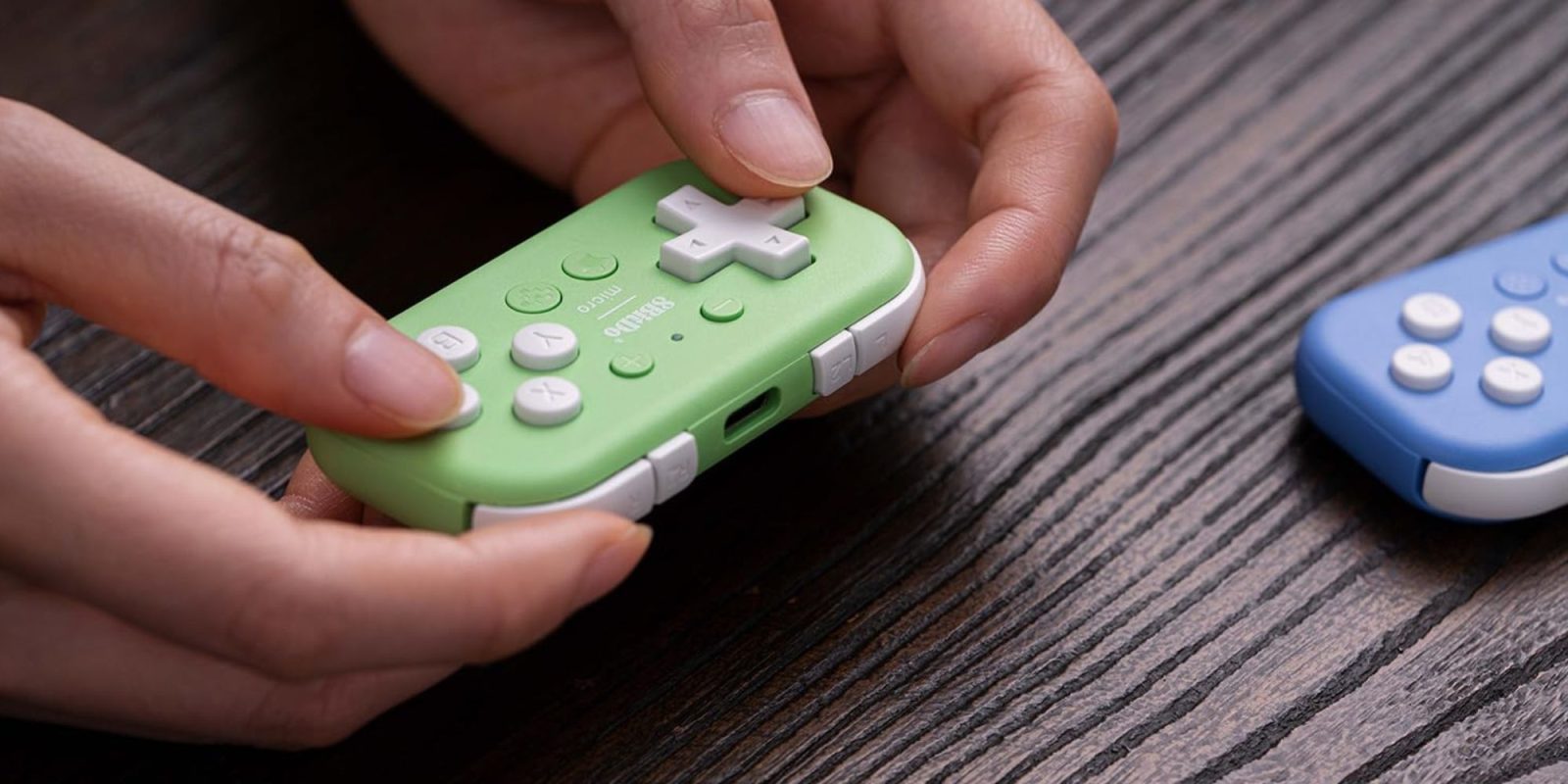 A person holding a green video game controller