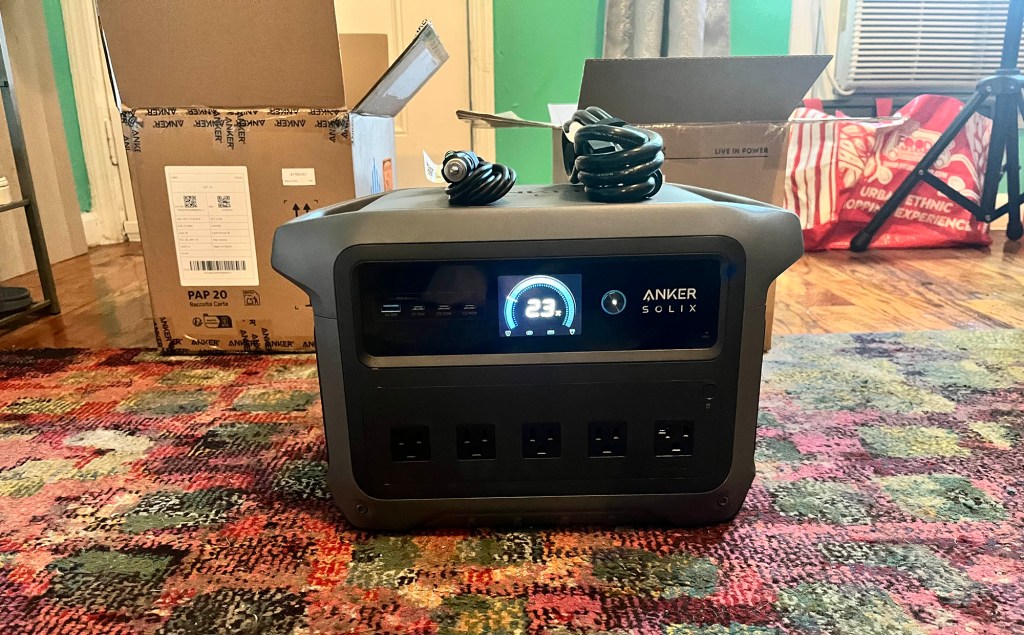 Anker's SOLIX C1000 Gen 2 power station with a lit-up display and charging cables on top