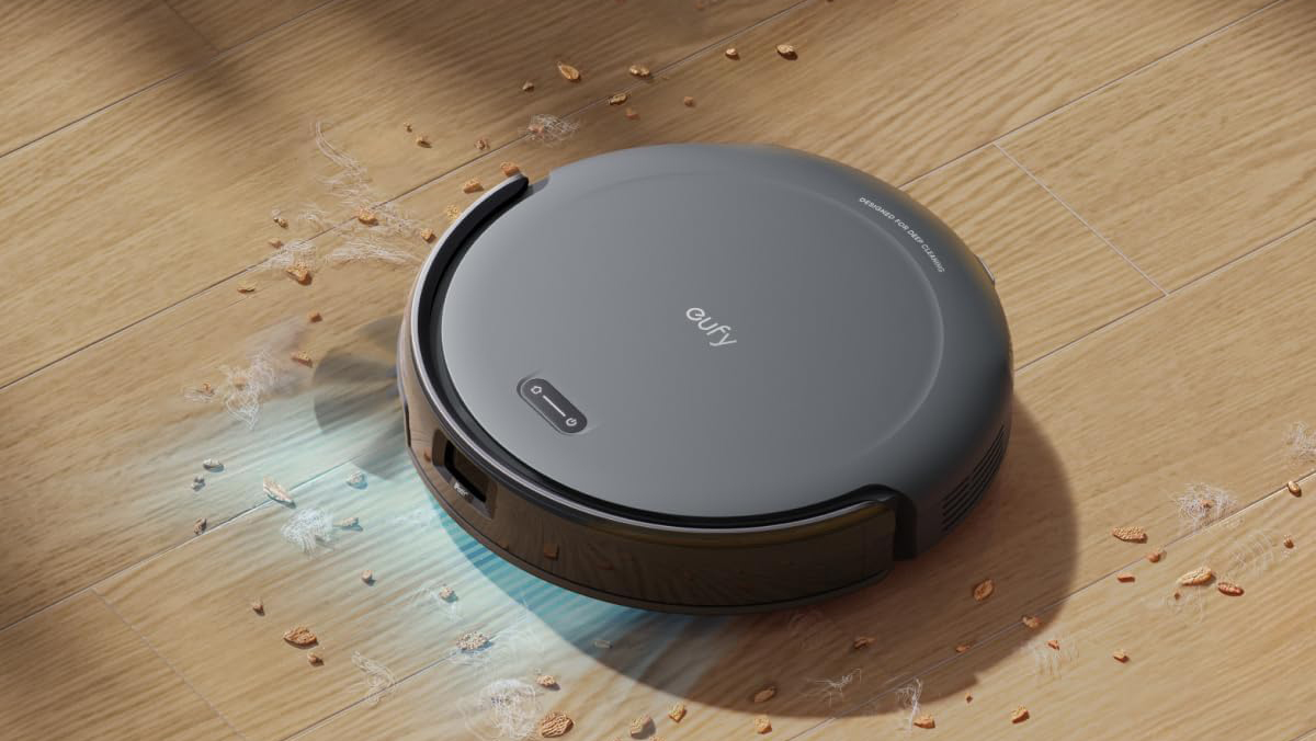 A black robot vacuum cleaner on a wood floor