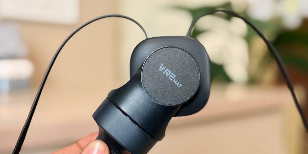 A hand holding a black device