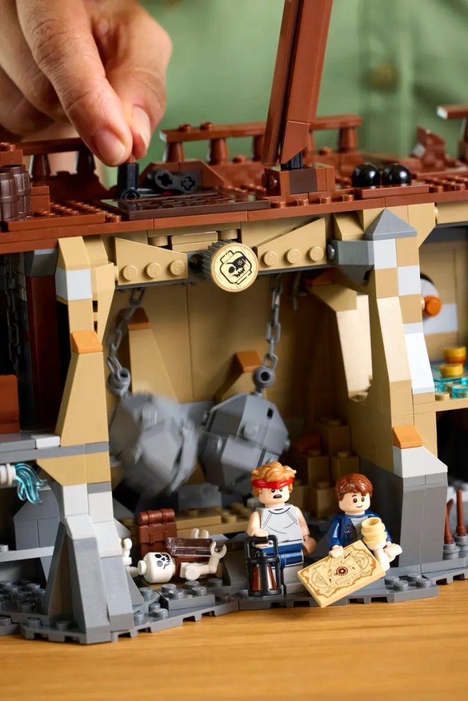 A hand holding a toy building in LEGO Idea The Goonies