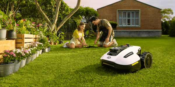 A man and a girl sitting on grass in a yard