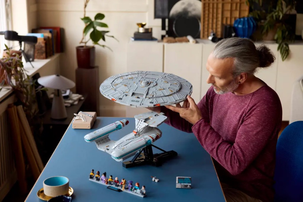 A man holding a model of a spaceship