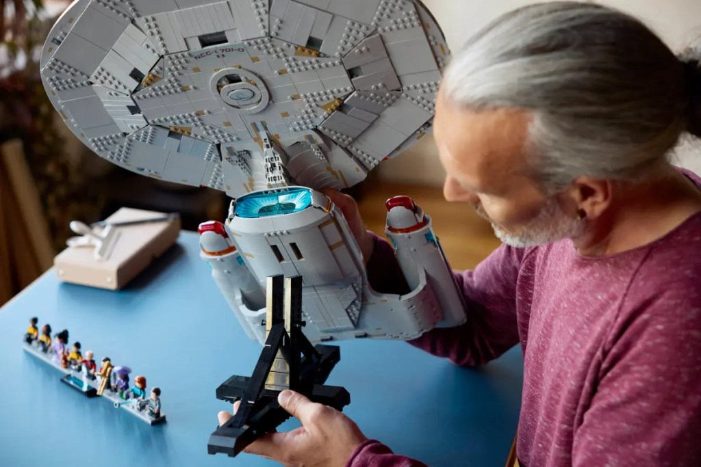 A man holding a model of a space ship