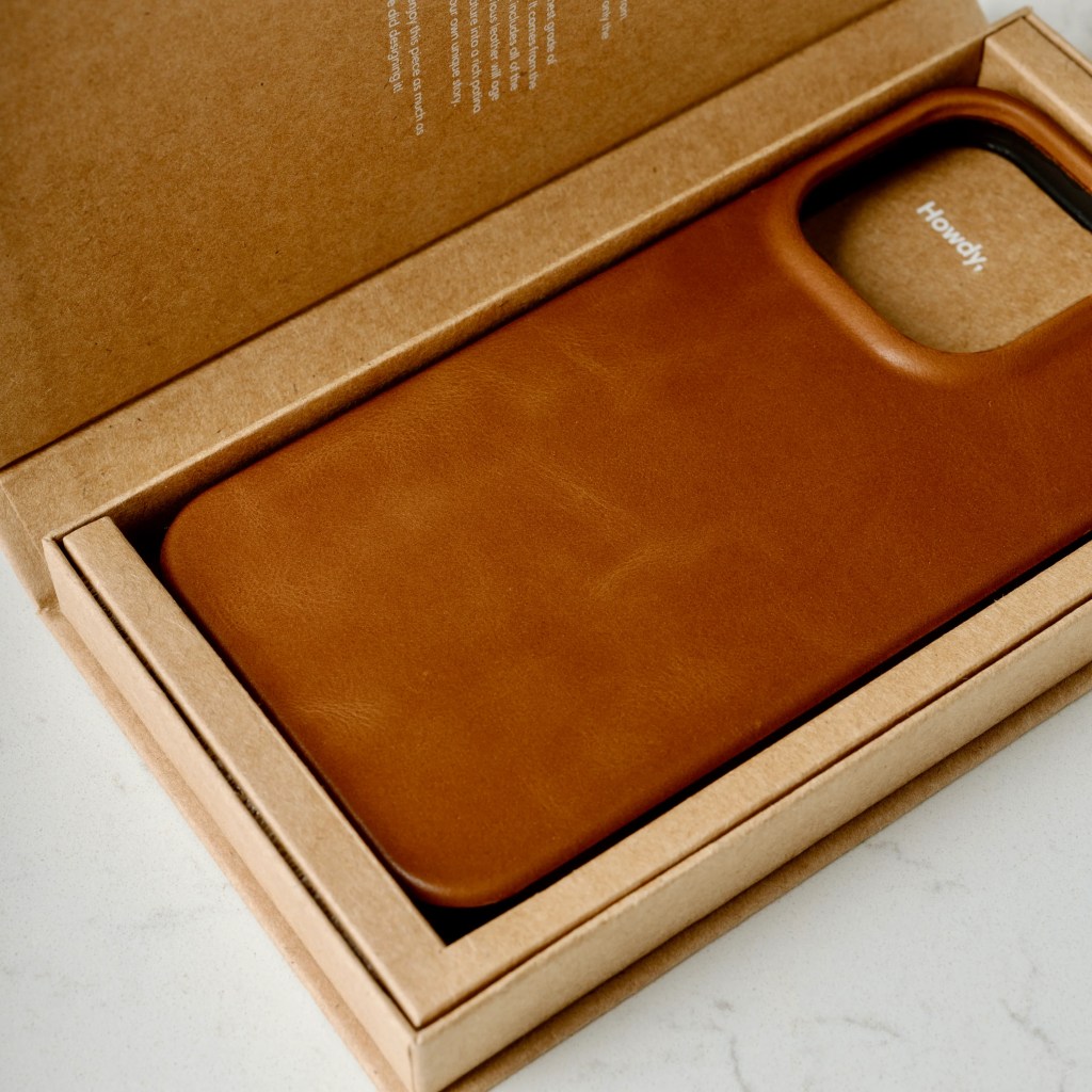 A brown leather phone case in a box